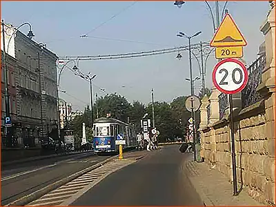znak A-11a i tabliczka T-1 zwolnij do 20 km/h, bo za 20 metrów będzie próg zwalniający