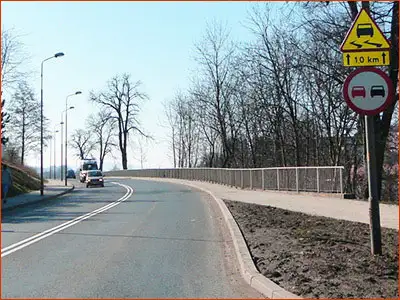 znak A-15 i tabliczka T-2 możliwość poślizgu pojazdu na odcinku 1 kilometra