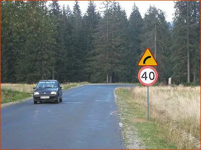 znak A-1 i B-33 ograniczenie prędkości na niebezpiecznym zakręcie