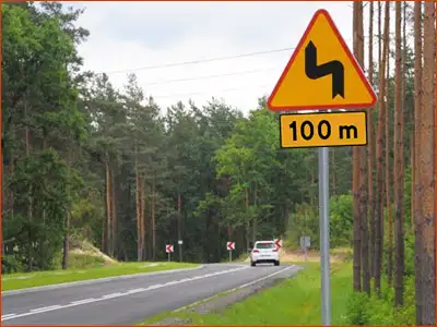 znak A-4 i tabliczka T-1 pierwszy zakręt w lewo będzie za sto metrów