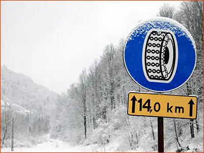 znak C-18 i tabliczka T-2 obowiązek używania łańcuchów na odcinku 14 kilometrów