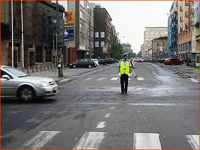 policjant stojący przodem zabrania wjazdu policjant stojący przodem zabrania wjazdu