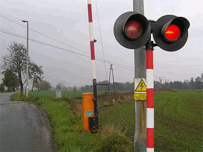 migające czerwone światło włączona sygnalizacja świetlna przed przejazdem