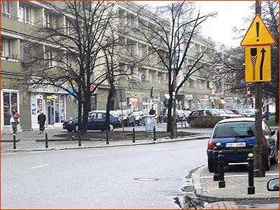 tabliczkaT-18 i znak A-30 zmiana kierunku drogi przez wysepkę na jezdni
